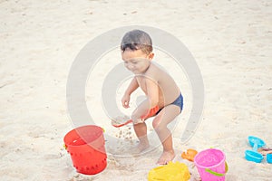 Baby boy playing with beach toys