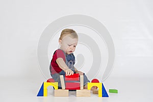 Baby boy playing with brightly coloured wooden blocks