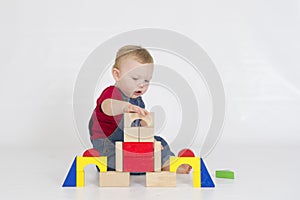 Baby boy playing with brightly coloured wooden blocks