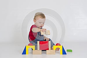 Baby boy playing with brightly coloured wooden blocks