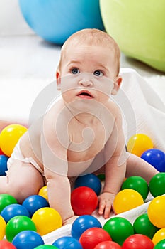 Baby boy playing with colorful plastic balls