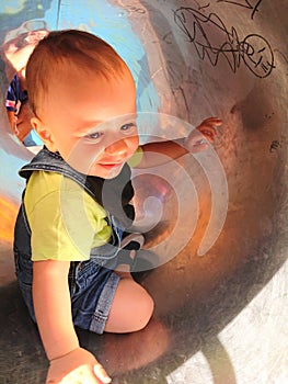 Baby boy playing and discovering tubes