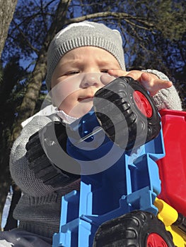 Baby boy playing with dump truck in the park