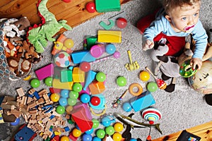 baby boy playing with his toys on the floor photo