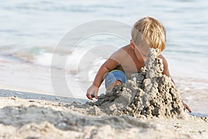 Baby boy playing with sand