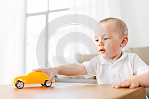 Baby boy playing with toy car at home