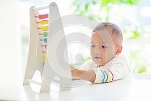 Baby boy playing with wooden abacus