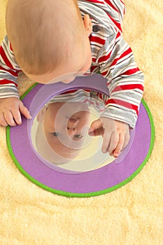 Baby boy plays with mirror