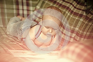 Baby boy read book on sofa