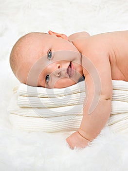 Baby boy relaxing on stack of towels