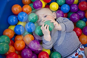 Baby boy with reusable nappy diaper in ball pond