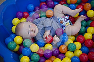 Baby boy with reusable nappy diaper in ball pond