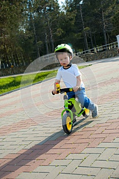 Baby boy riding on his first bike without pedals