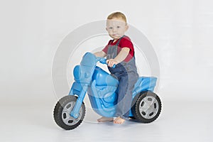 Baby boy riding his plastic scooter