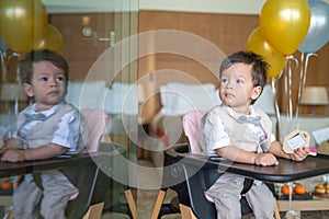 Baby boy's first birthday with cake in balloons