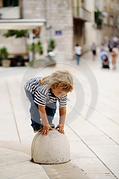 Baby boy on semisphere bollard