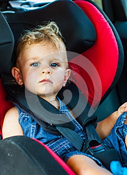 Baby boy sitting in car seat. Child transportation safety