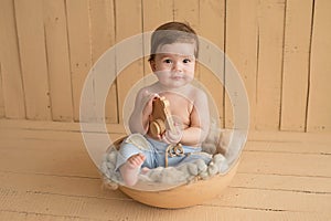 Baby boy sitting on crib. Children Protection Day. Happy childhood. Early child development. Educational wooden toys. Mother`s da