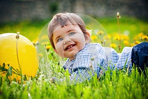 Baby boy sitting on the grass in field