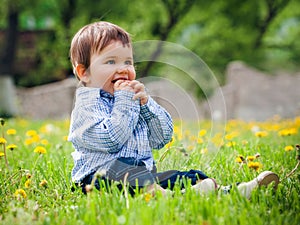 Baby boy sitting on the grass in field