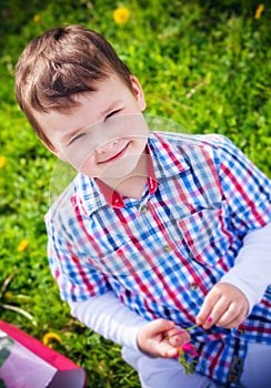 Baby boy sitting on the grass in field