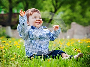 Baby boy sitting on the grass in field