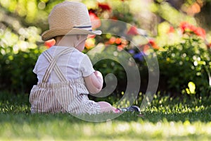 Baby boy sitting on the grass in the garden on beautiful spring