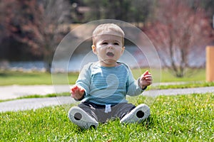 Baby boy sitting on grass in summer