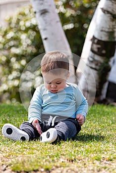 Baby boy sitting on grass in summer