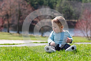 Baby boy sitting on grass in summer