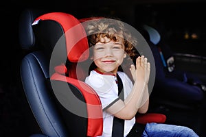 Baby boy sitting in a red child car seat