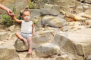 Baby boy sitting on rock