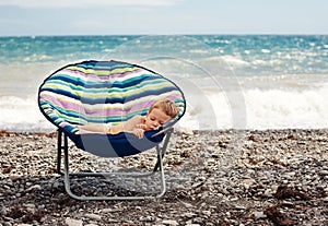 Baby boy sleeping on the beach