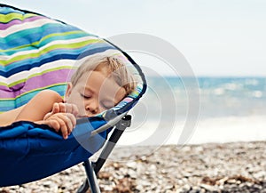 Baby boy sleeping on the beach