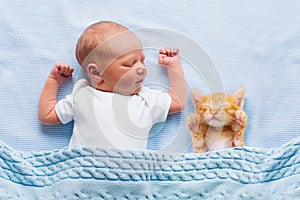 Baby boy sleeping with kitten. Child and cat