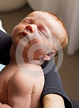 Baby boy sleeping in mothers arms