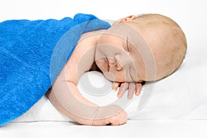 Baby boy sleeping on a white blanket