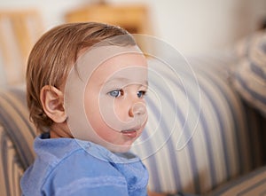 Baby boy, smile and face profile in sofa relaxing, resting and sitting in living room. Adorable child, growth and