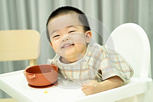 Baby boy smiling with dirty face after eating rice