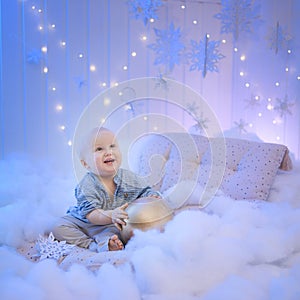 Baby boy  smiling and  with  tree, star and Christmas lights on the background