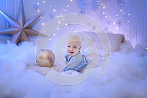 Baby boy  smiling and  with  tree, star and Christmas lights on the background