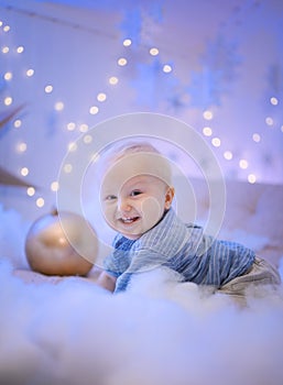 Baby boy  smiling and  with  tree, star and Christmas lights on the background