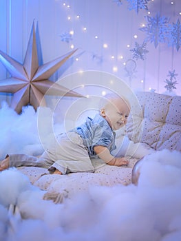 Baby boy  smiling and  with  tree, star and Christmas lights on the background