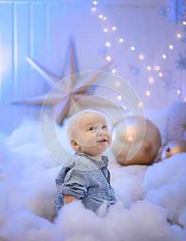 Baby boy  smiling and  with  tree, star and Christmas lights on the background