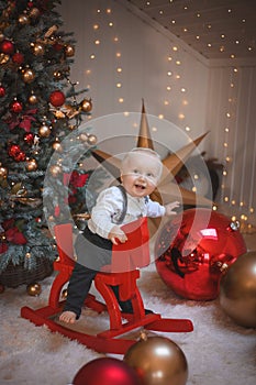 Baby boy  smiling and  with  tree, star and Christmas lights on the background