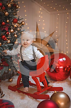 Baby boy  smiling and  with  tree, star and Christmas lights on the background