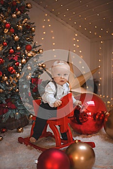 Baby boy  smiling and  with  tree, star and Christmas lights on the background