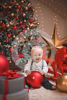 Baby boy  smiling and  with  tree, star and Christmas lights on the background