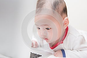 Baby boy starring at laptop