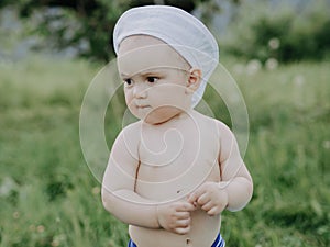 Baby boy summer day in a meadow with green grass